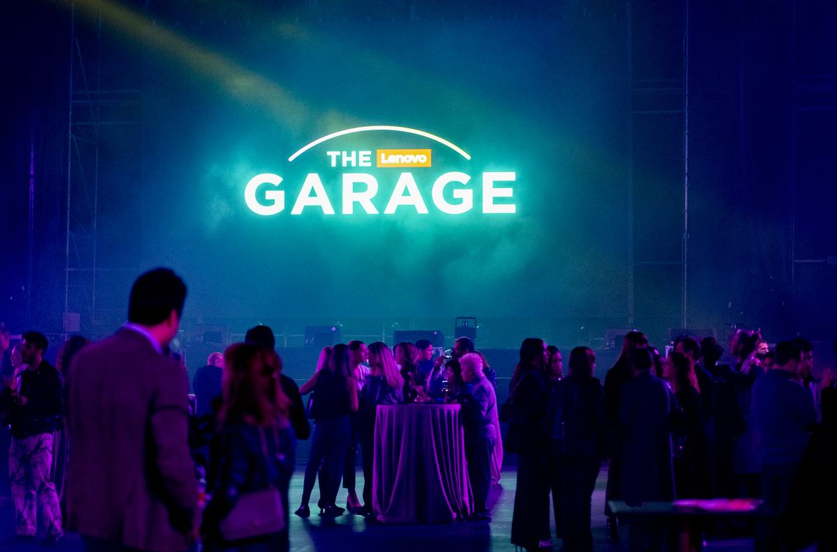 Invitados bajo el rótulo luminoso de The Lenovo Garage